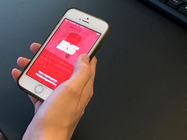 En hånd holder en iPhone, der viser Betalingsservice-app'en. || BM-oko-Betalinsservice.jpg