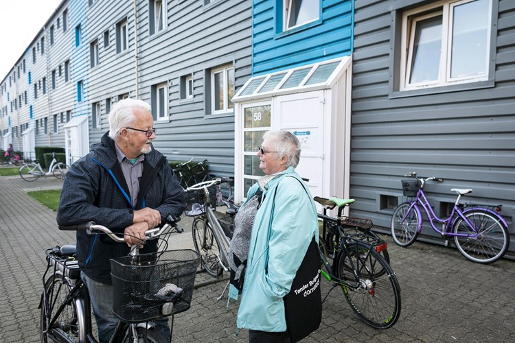 En ældre mand står og snakker med en ældre kvinde foran en boligblok i afdelingen Tønder-Rømø Byhuse. || Tonder-Boligselskab,-Allis.jpg