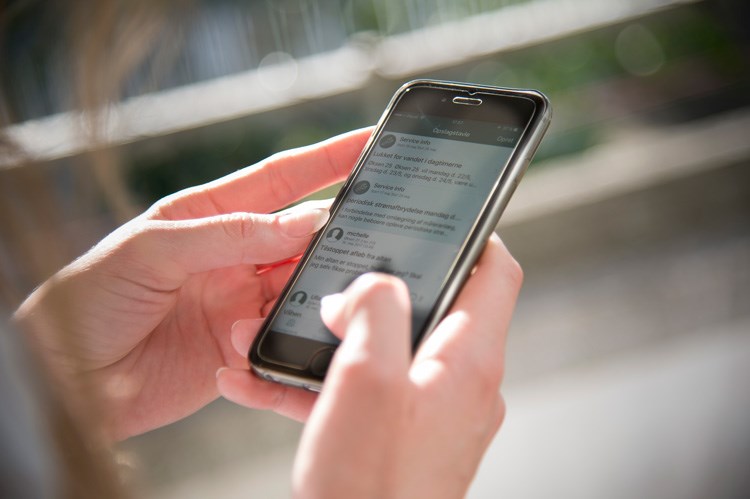 Kvinde viser beboer-app'en Min boligservice på sin iPhone. || BM-reparationer-app-JL-9849.jpg
