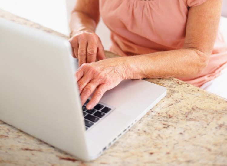 En ældre kvinde sidder ved en bærbar computer og taster. || BM-Opsigelse-af-bolig-shutterstock.jpg
