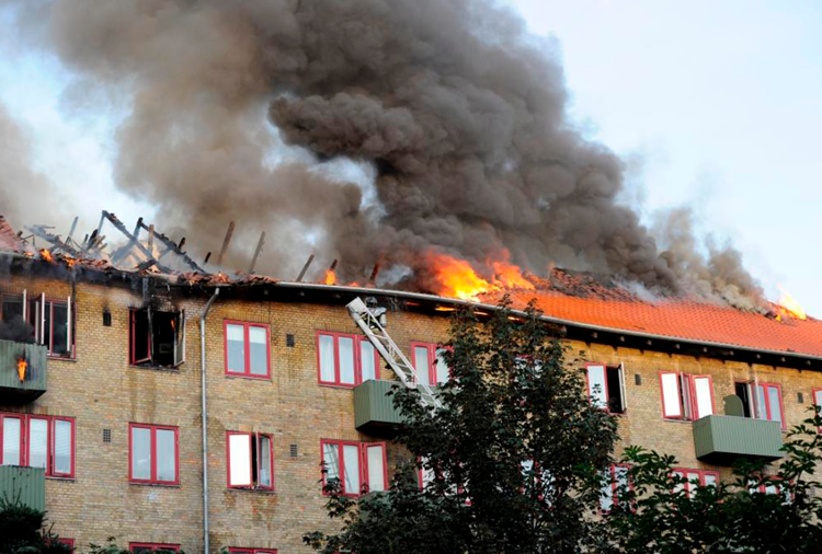 Det brænder i taget af en etagebygning med kraftig røgudvikling til følge. || Bo-brandsikkert-kursus_web.png