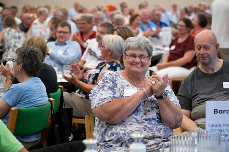 Glad kvinde sidder i sal og klapper sammen med en masse andre. || Landskonference2018_KU.png