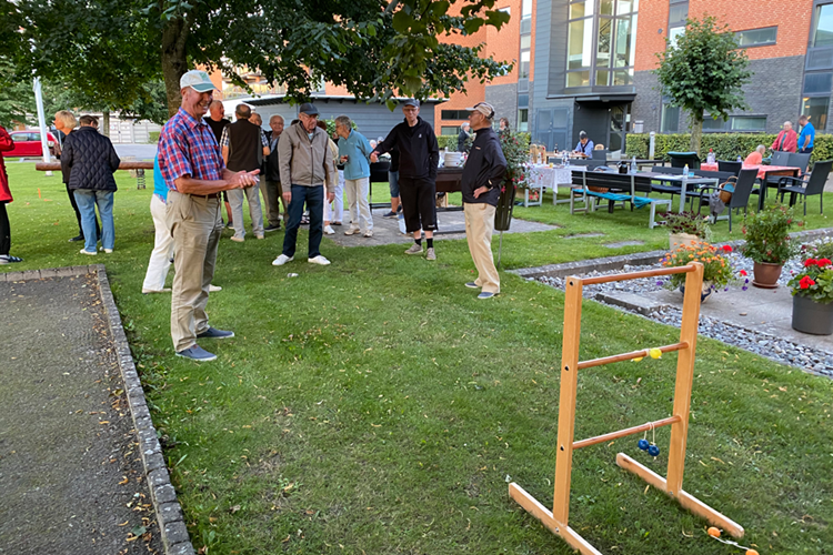 En flok mennesker spiller et spil på en græsplæne. || Hv Sommerfest Spil Web