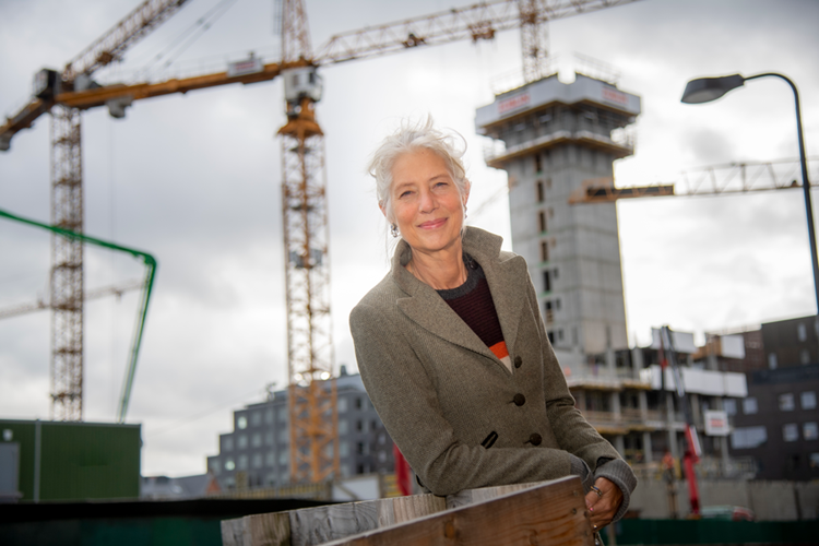 Portræt af Mette Mogensen med en byggeplads i baggrunden. || Mettemogensen Web