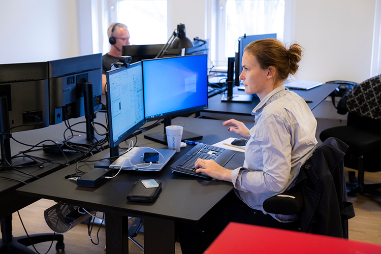 Kvinde sidder ved sit skrivebord og kigger ind i computeren || EG Live Web