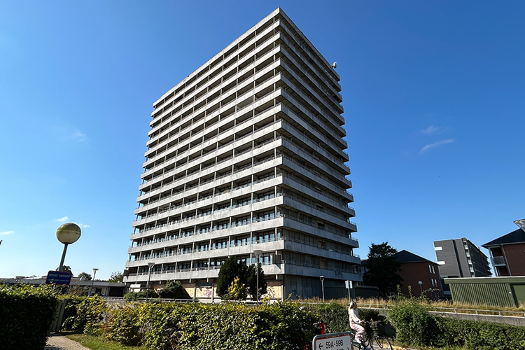 Højhuset set skråt nedefra. Blå himmel. || Hojhuset Web