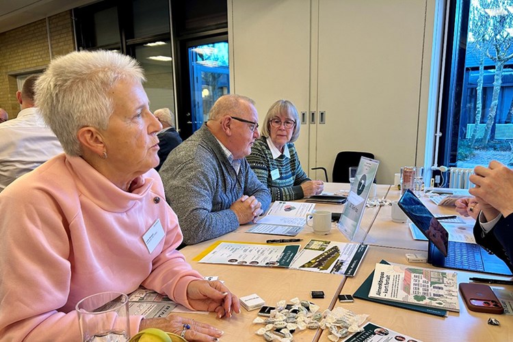 To kvinder og en mand sidder ved bord til konference || Domea Regionsmoeder26 Web 900X600