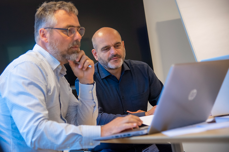 To mænd - de nuværende regionsdirektører i Domea.dk - sidder og kigger på computer. || Domea Regionsaendring Web 900X600